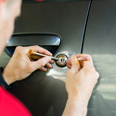locksmith opening car door with lockpicker Broken key