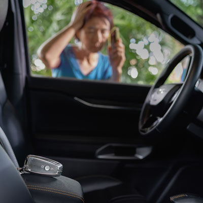 Senior asian woman forgot her key inside locked car. Locked out vehicle entry